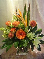 Bird of paradise, dahlia, roses, gerbera, lillies, solidago, and fatsia japonica