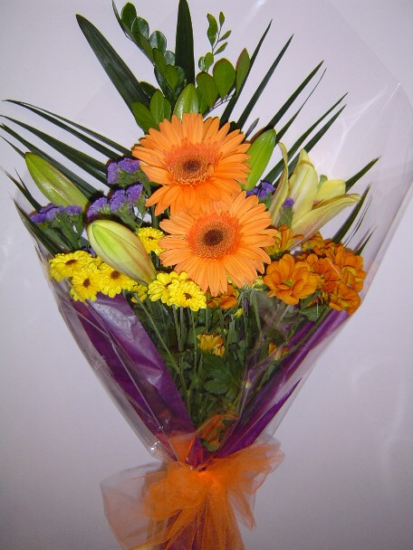 Gerbera, lilies, statice, daisies, and greens
