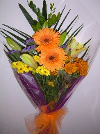 Gerbera, shocking lillies, statice, daisies, and greens
