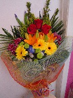 Roses, gerbera, pompoms, iris, solidago, lillies, daisies, and campanula