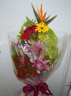 Bird of paradise, roses, gerbera, lillies, lisianthus, anthurium, solidago, and berries
