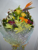 Bird of paradise, iris, lillies, roses, gerbera, coffee beans, daisies, and solidago