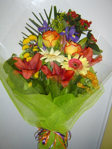 Roses, gerbera, iris, daisies, lilies, pompoms, solidago, and hypericum