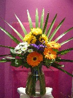 Sunflower, gerbera, statice, pompoms, and palmetto