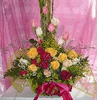 Mixed roses, solidago, genest, limonium, and greens in a basket