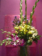 Alstroemeria, pompoms, dendrobium orchids, gladiolas, monte casino blue, and monkey grass