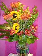 Protea, sunflowers, solidago, alstroemeria, and monstera