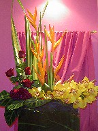 Heliconia, roses, celosia, cymbidium orchids, zebra leaves, and tea leaves