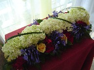 Hydreangia, agapanthus, yellow and red roses, red tulips, and monkey grass