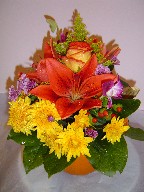Lillies, roses, solidago, orchids, daisies, and coffee beans in a pumpkin