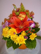 Lillies, roses, solidago, orchids, daisies, and coffee beans in a pumpkin