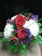 Roses, spider mums, statice, hypericum, waxflowers, and steel grass