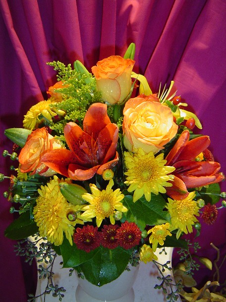 Lilies, roses, solidago, hypericum, daisies, and seeded eucalyptus