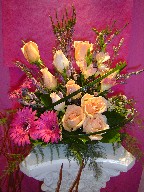 Heather, gerbera, roses, freesia, waxflowers, and monkey grass