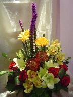 Cymbidium orchids, protea, roses, gerbera, lillies, liatris, and cordeline
