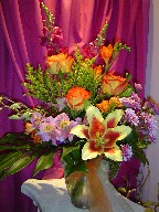 Shocking lillies, roses, daisies, alstroemeria, fresia, snapdragon, solidago, and monstera