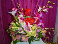 Roses, orchids, lillies, alstroemeria, waxflowers, and monkey grass