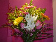 Gerbera, lillies, tulips, roses, solidago, and waxflowers