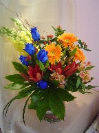 Roses, snapdragon, gerbera, lilies, alstroemeria, curly willow, hypericum, and fatsia japonica