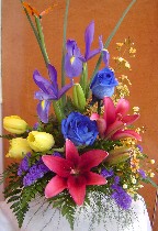 Yellow tulips, irises, blue roses, tiger lillies, waxflowers, and statice