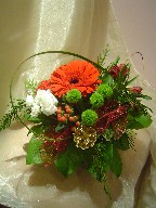 Gerbera, carnations, pompoms, alstroemeria, hypericum, monkey grass, and Christmas decorations