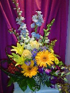 Delphinium, roses, gerbera, lillies, snapdragon, solidago, orchids, daisies, monte casino blue, and seed eucalyptus