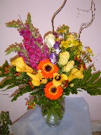 Snapdragon, calla lillies, roses, lithianthus, coffee beans, helenium, philodendron, and curly willow