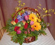 Oncidium orchids, agapanthus, tulips, roses, wax flowers, gerbera, alstroemeria, and asiatic lillies in a basket