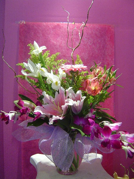 Dendrobium orchids, lilies, iris, gerbera, alstroemeria, solidago, and branch