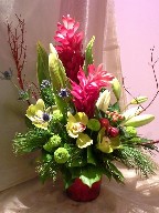 Ginger, cymbidium orchids, asiatic lillies, pompoms, thistle, cordeline, cedar, and branch