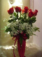 Dozen red roses with baby's breath in a vase