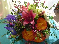 Iris, boronia, daisies, ranunclus, pink lilies and circle roses in a basket