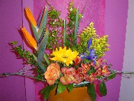 Bird of paradise, sunflower, solidago, iris, roses, and alstroemeria