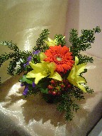Gerbera, lillies, hypericum, statice, and pine
