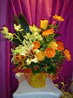 Shocking lillies, orchids, gerbera, roses, pompoms, coffee beans, solidago, and sago palm