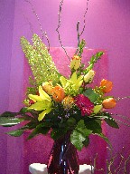 Roses, eremurus, tulips, gerbera, lillies, curly willow, waxflowers, solidago, monstera, and monkey grass 