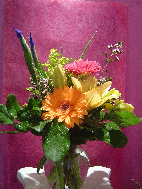 Gerbera, iris, solidago, lilies, and waxflowers