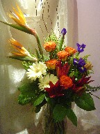 Bird of paradise, iris, roses, gerbera, lillies, solidago, and curly willow