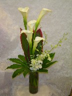 Calla lillies, dendrobium orchids, cordyline, and fatsia japonica