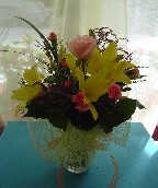 Limonium, osiana rose, yellow lilies, and mini carnations in a vase