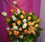 Cream, orange, and circus roses, berries, and tiger lillies in a basket