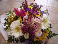 White gerbera, tulips, heather, button daisies, casiomoto, waxflowers, and anna roses in a basket