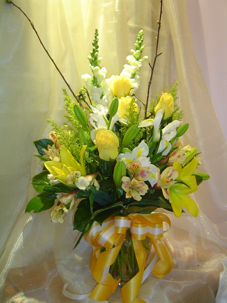 Roses, snapdragon, lilies, iris, alstroemeria, solidago, and branch