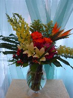 Bird of paradise, snapdragon, roses, gerbera, lillies, orchids, coffee beans, gerbera, and monstera