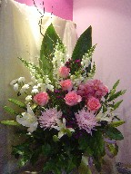 Roses, lillies, cymbidium orchids, snapdragon, pompoms, spider mums, cordeline, and curly willow