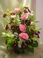Roses, lillies, daisies, snapdragon, fresia, solidago, and monkey grass