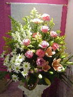 Roses, daisies, solidago, snapdragon, lillies, alstroemeria, and carnations in a basket