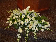 Calla lily, orchids, roses, daisies, baby's breath, and green pompoms