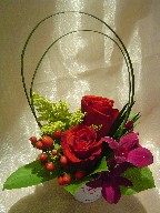 Roses, dendrobium orchids, hypericum, solidago, and monkey grass